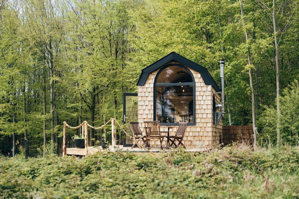绍蒙－吉斯图Tiny House Au Coeur de la Campagne Wallonne的森林中央带椅子的凉亭