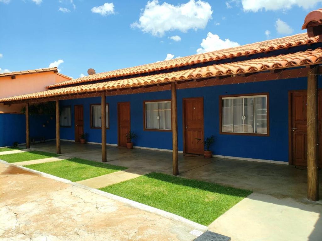 卡皮托利乌Pousada Recanto Rainha do Lago的蓝色房子,有红色屋顶