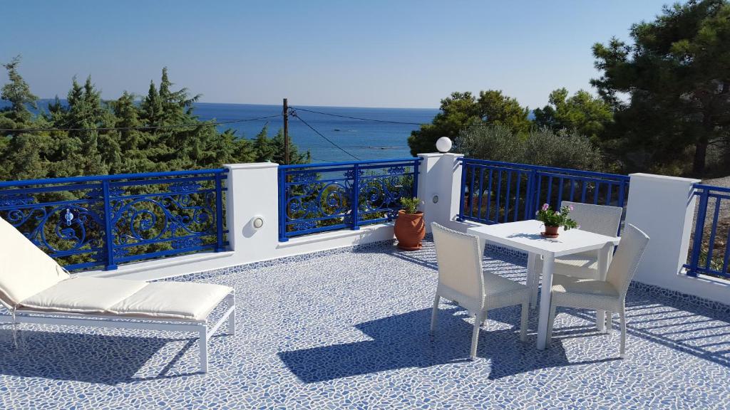阿彻奇洛斯Mediterraneo Apartments的阳台的天井配有2把椅子和1张桌子