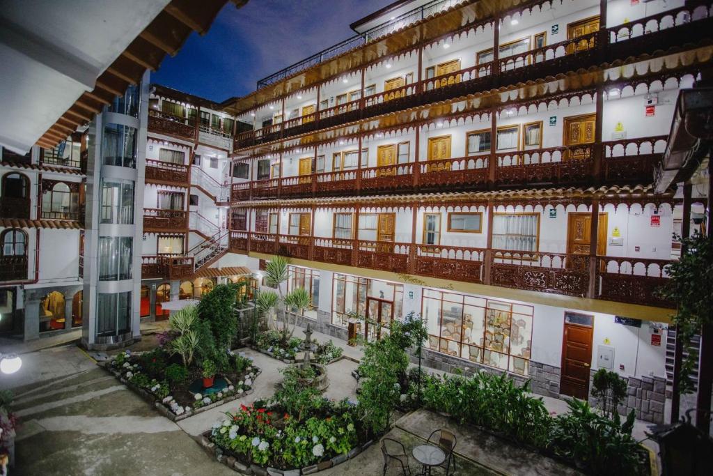 库斯科Quechua Hotel Cusco的公寓大楼设有阳台和种有植物的庭院。