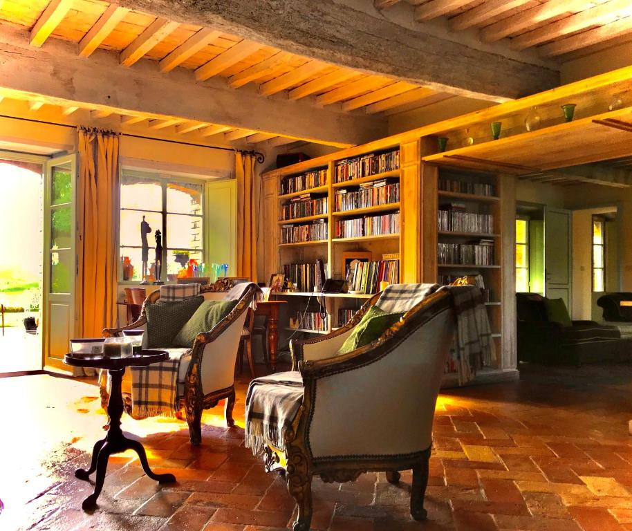 ContignanoDimora Buonriposo Pienza Country House的图书馆配有椅子、桌子和书架