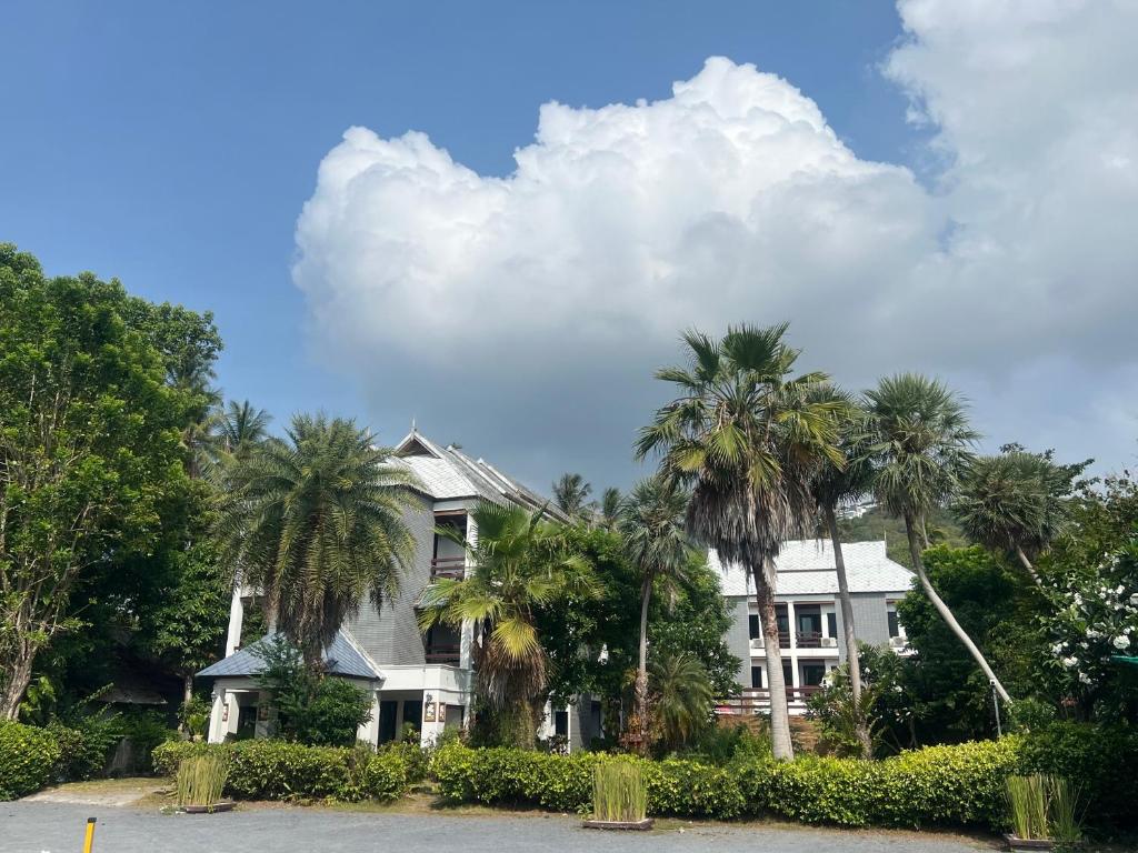 拉迈苏梅岛海风广场酒店的前面有棕榈树的房子