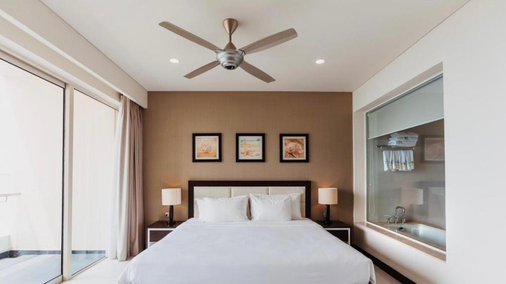 芽庄Central Nha Trang Apartment的一间卧室配有一张带吊扇的床