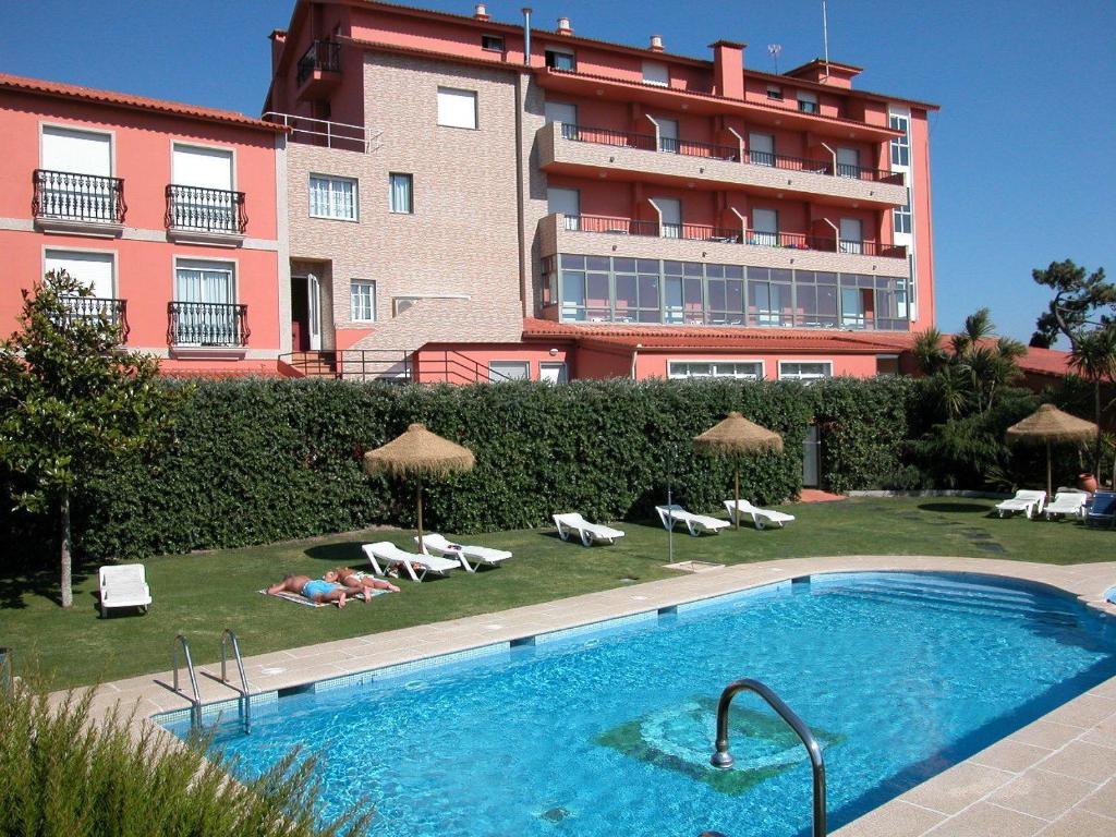波多诺伏Hotel VIDA Playa Paxariñas的一座大建筑前的游泳池