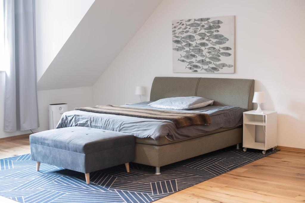 莱比锡Apartment mit Parkblick & Massagestuhl的一间卧室配有一张床和一张搁脚凳