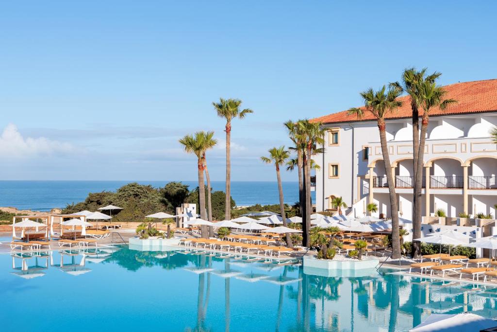 奇克拉纳－德拉弗龙特拉Iberostar Selection Andalucia Playa的酒店拥有带椅子和棕榈树的游泳池