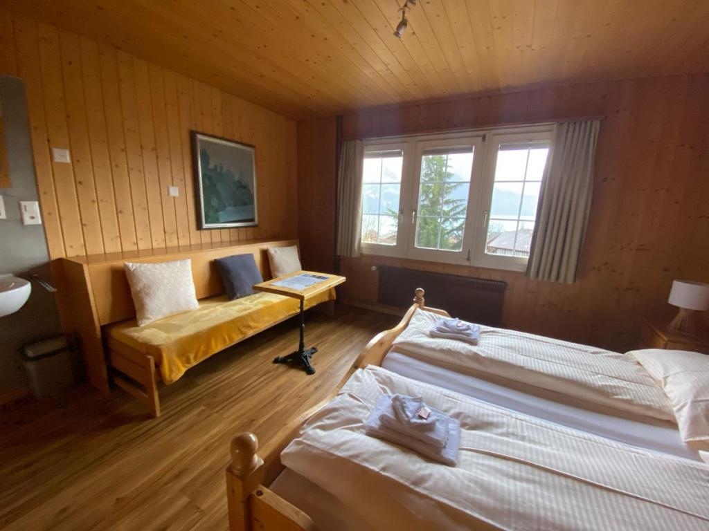 布里恩茨B & B Brienz的一间卧室配有两张床和一张沙发。