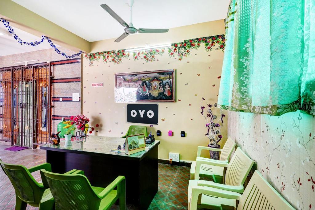 蒂鲁帕蒂OYO SS Home Stay - An Unique Home Stay的客房配有书桌和绿色椅子。