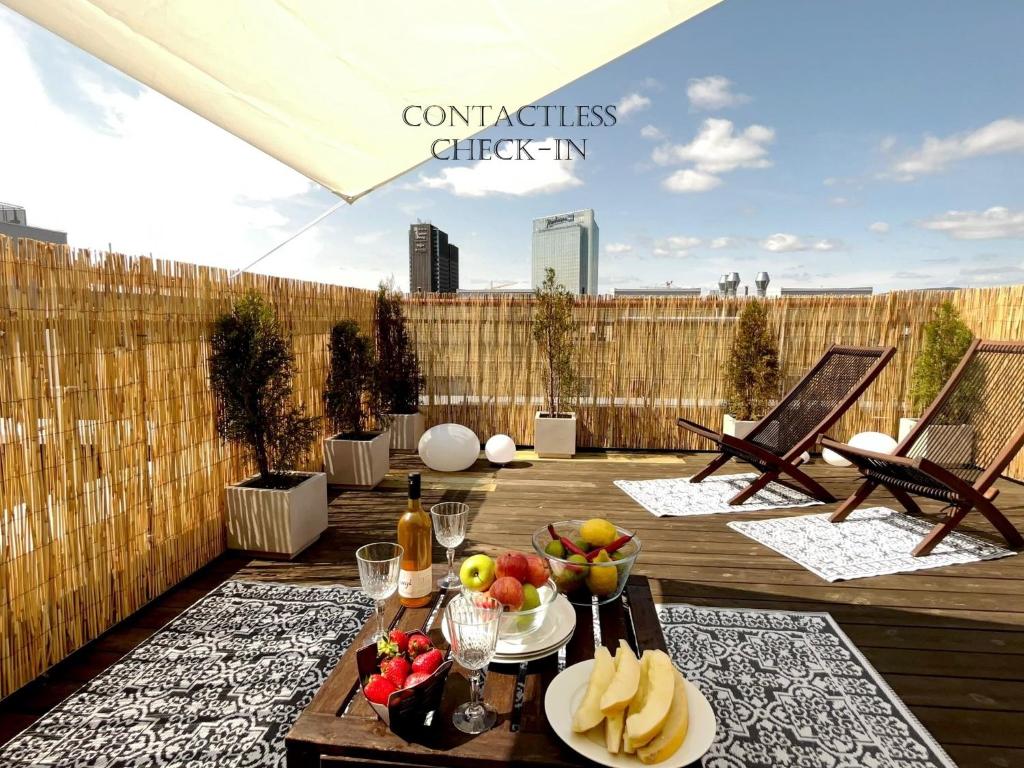 奥斯陆City center flat w roof top terrace & free parking的露台设有一张桌子,甲板上摆放着水果
