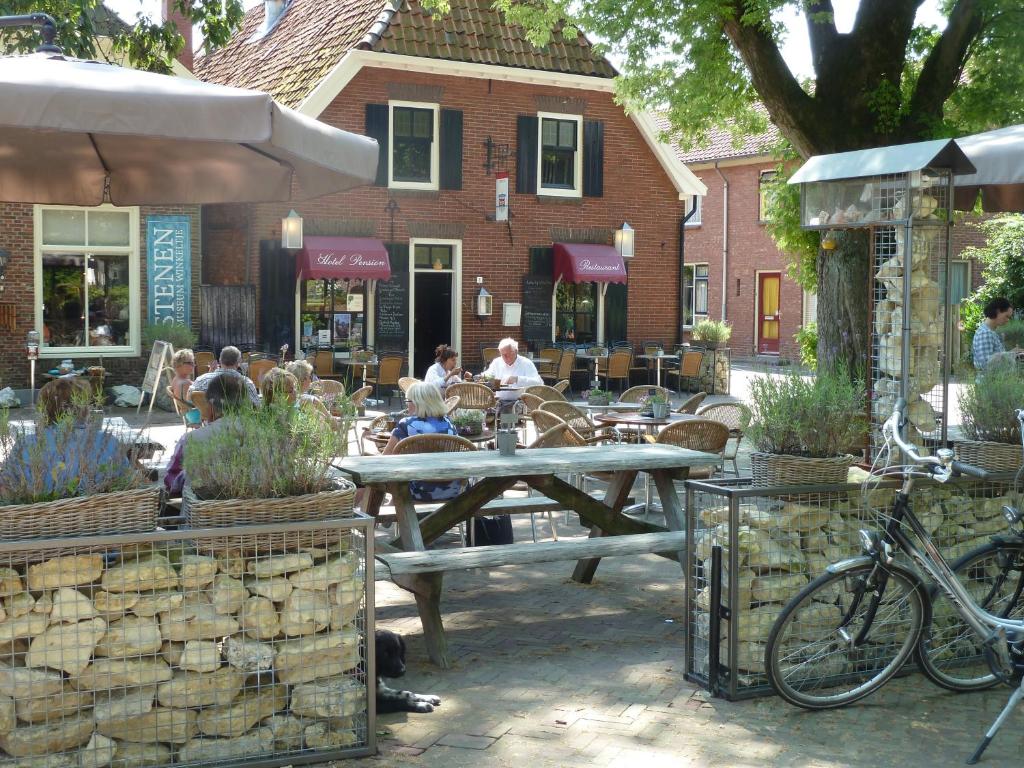 BredevoortHotel Bertram的一个带桌椅的庭院和一座建筑
