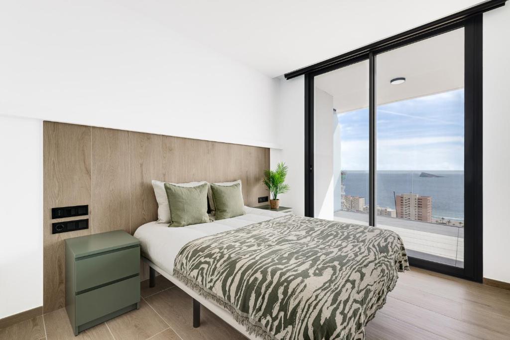 贝尼多姆SAKURA by Costa Activa Rentals的一间卧室设有一张大床和一个大窗户