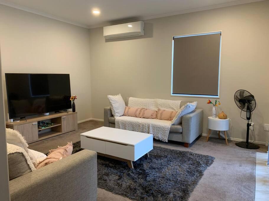 奥克兰Serene 5-Bedroom Papakura Home的带沙发和平面电视的客厅