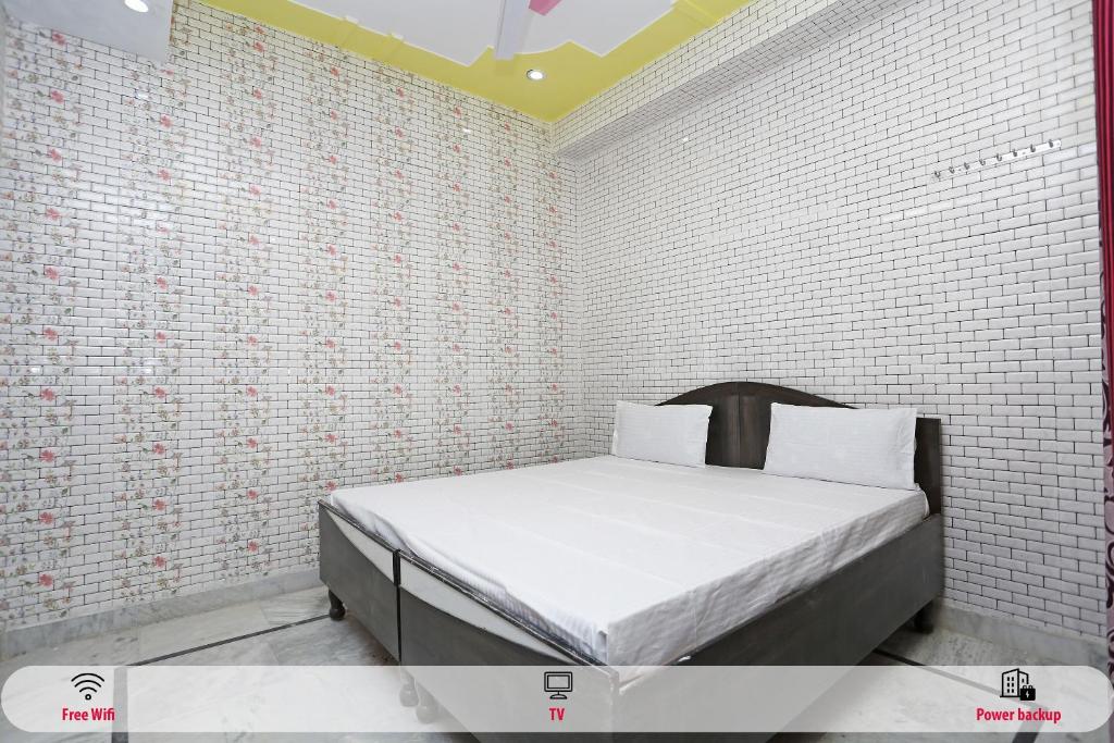 鲁尔基SPOT ON Hotel Doon Sabri的卧室配有白色砖墙内的床铺