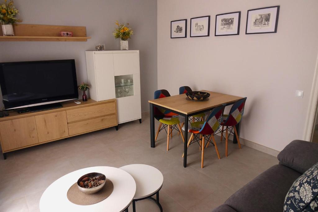 特伦普apartament dúplex "Alsina"的客厅配有电视和桌椅
