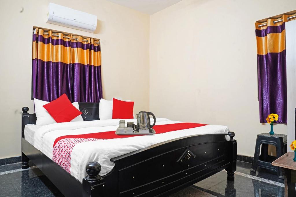 GunadalaOYO NSK Mahanadu Extension的一间卧室配有红色和橙色枕头的床