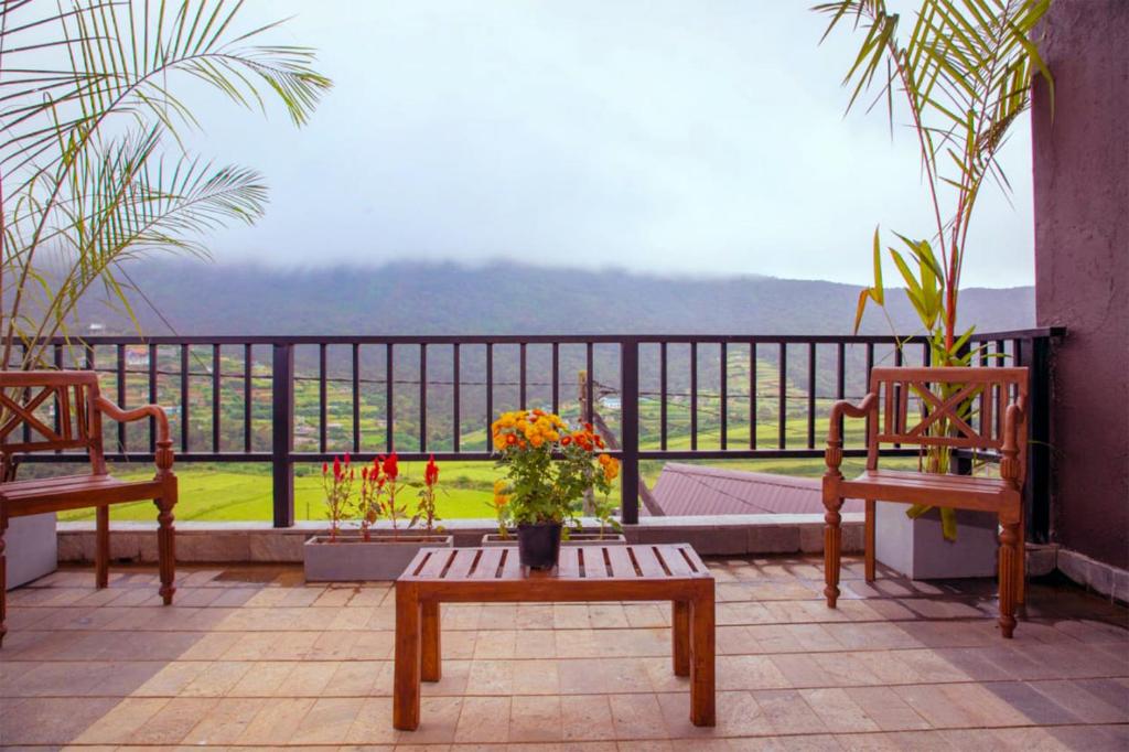 努沃勒埃利耶Aquaa Leaf Residences的阳台配有两把椅子和一张鲜花桌子