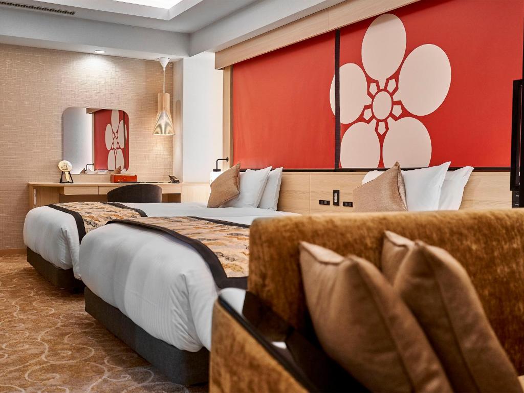 金泽Daiwa Roynet Hotel KANAZAWA-MIYABI的酒店客房设有两张床和红色的墙壁。