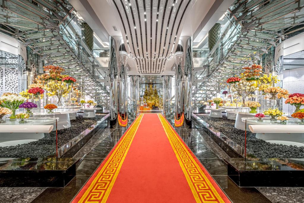 迪拜Golden Sands Boutique Hotel-Dubai Creek的大楼里一条红地毯的过道,花朵满天