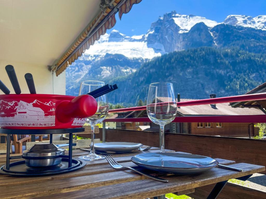 坎德施泰格Swiss Alps Lodge的山顶上带酒杯的桌子