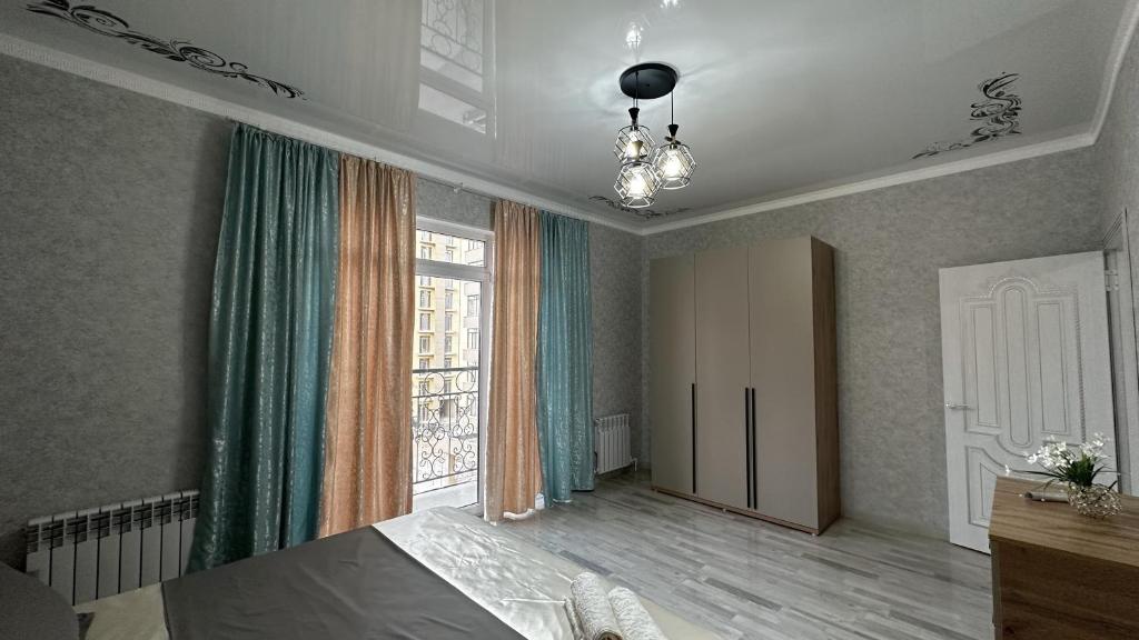 Tridtsatʼ Let KazakhstanaКвартира в Туркестане的一间卧室设有一张床和一个大窗户