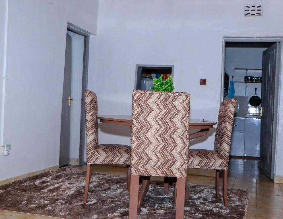 MeruPerfection的一间带桌子和两把椅子的用餐室