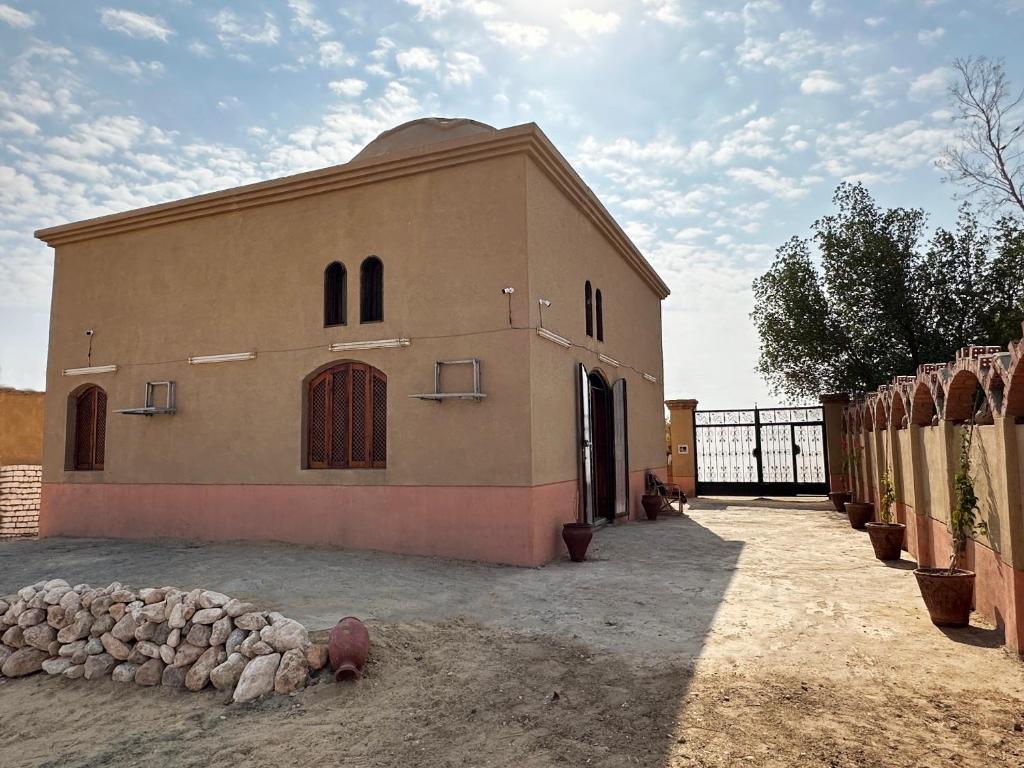 ‘Ezbet Abu ḤabashiThe Desert House, Luxor, Westbank的旁边设有围栏的大建筑