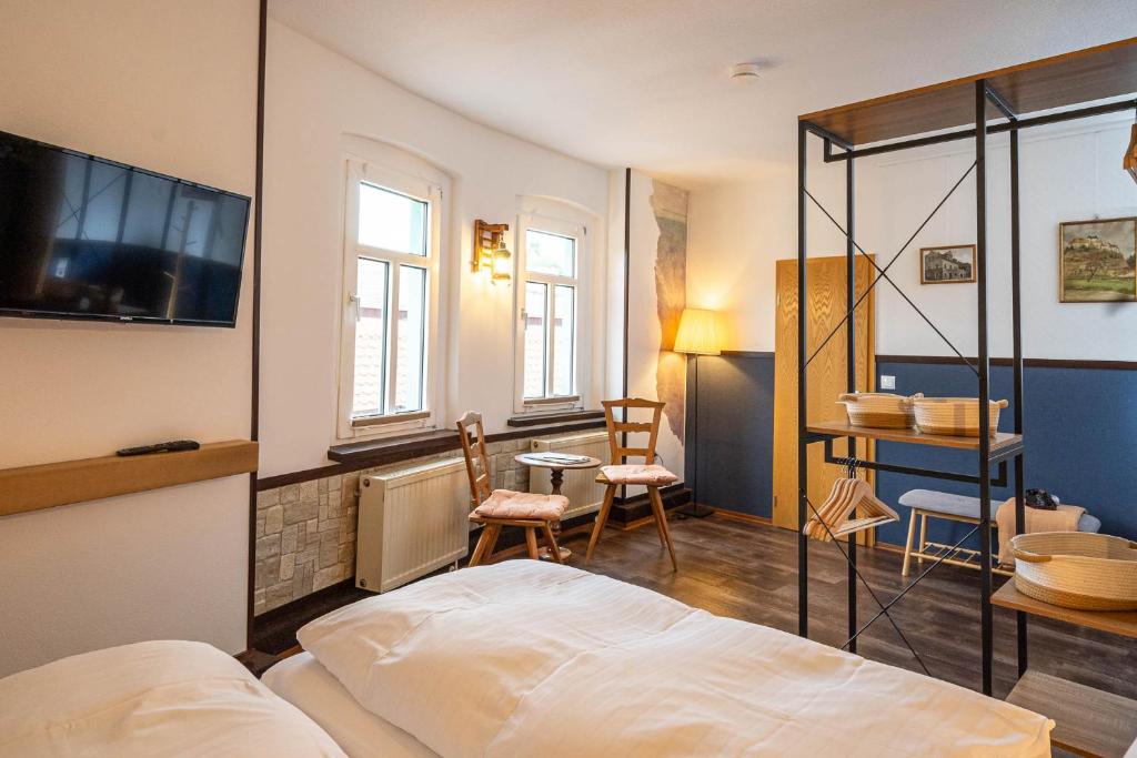 弗赖堡Pension Zur Neuenburg的卧室配有一张床和一张桌子及椅子
