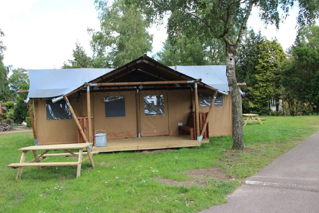 皮滕Verblijf in de Veluwe met Privé sanitair LL54的田野上的帐篷,有桌子和树
