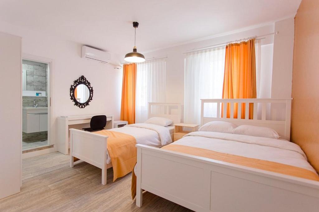 博兹贾阿达岛Ada Kalimera Bozcaada的一间卧室配有两张床、一张桌子和一面镜子