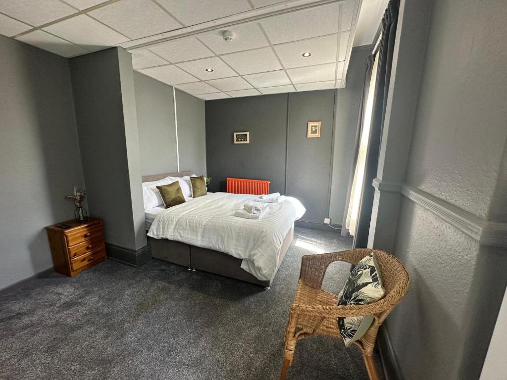 曼彻斯特Manchester Stay Hotel - Free Parking的一间卧室配有一张带镜子和椅子的床