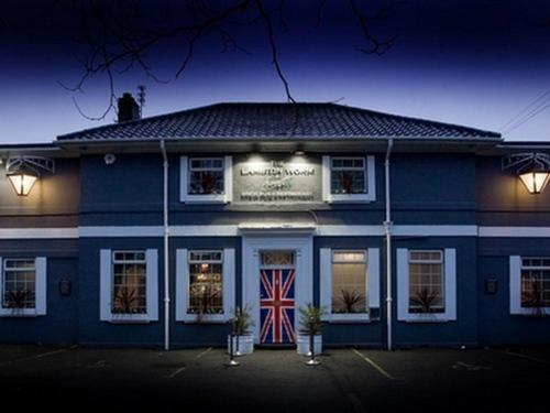 切斯特勒斯特里特莱姆顿沃姆住宿加早餐旅馆的前方有英国国旗的蓝色建筑