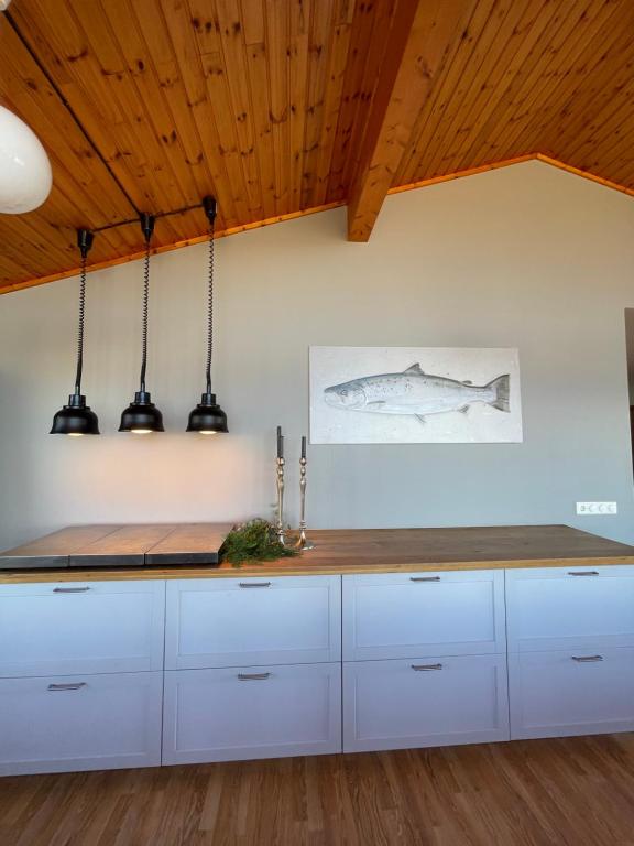 LaxamýriVökuholt Lodge的厨房配有白色橱柜和木制天花板。