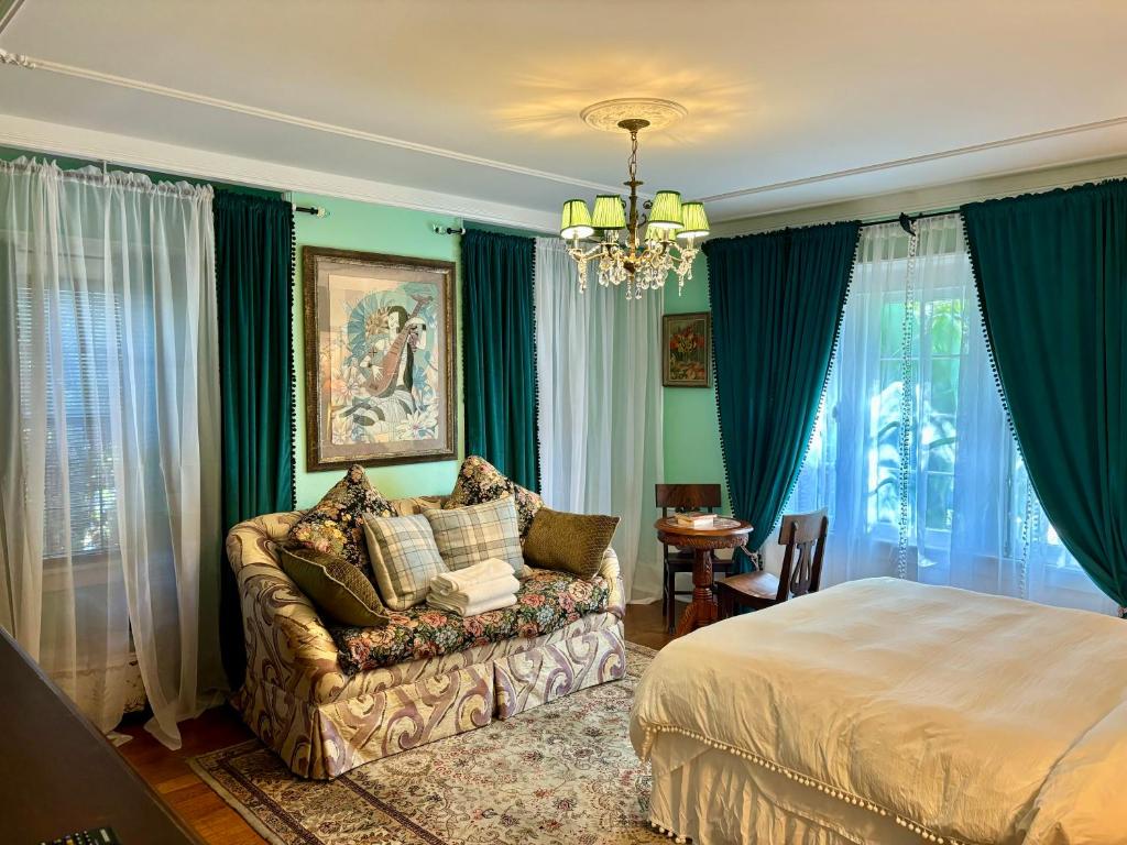 洛杉矶Hollywood Home的一间卧室配有一张床、一张沙发和一个吊灯。