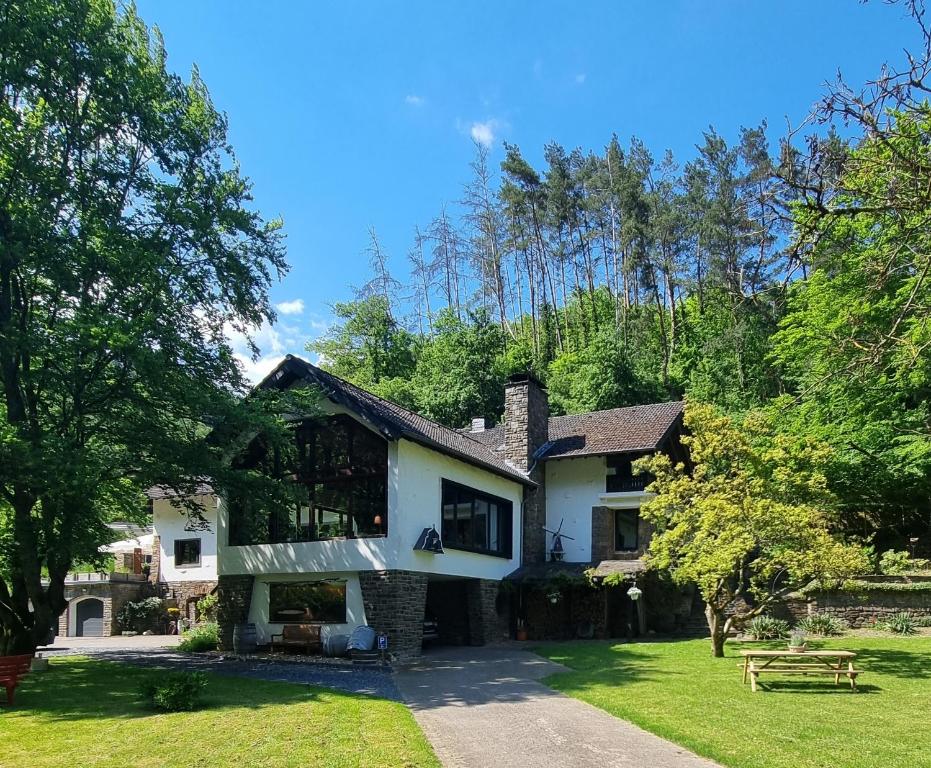 阿尔特纳尔B&B Am Sahrbach的一座白色的房屋,有树木和草地庭院
