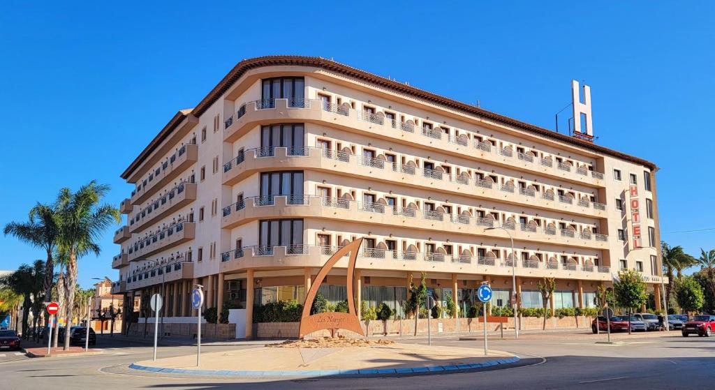 洛斯阿尔卡萨雷斯Hotel Monarque Costa Narejos的一座大建筑,前面有雕塑