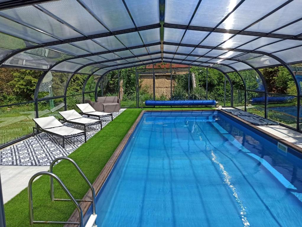 MoyonLa Petellerie, maison de campagne avec piscine pour un séjour détente的游泳池上方设有可伸缩屋顶