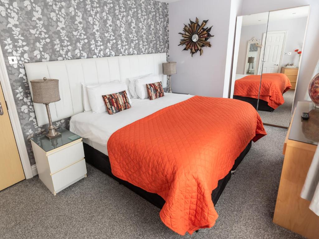 布莱克浦The Kenley Hotel的一间卧室配有一张带橙色毯子的大床