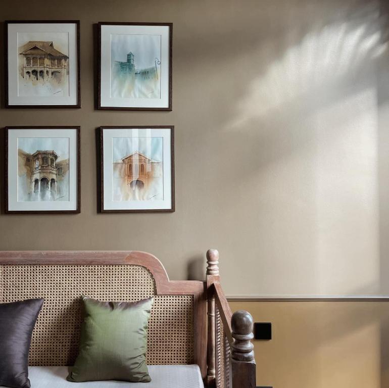 普吉镇Hotel Verdigris的客厅配有沙发和墙上的照片