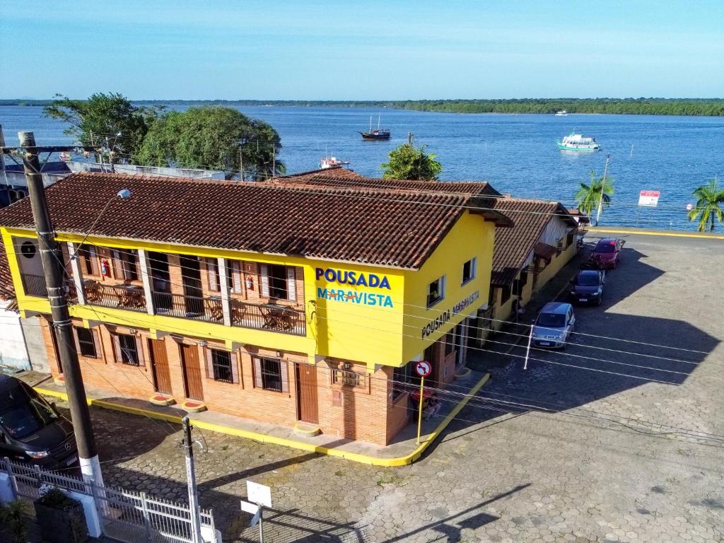 卡纳内亚Pousada Maravista的靠近水体的黄色建筑