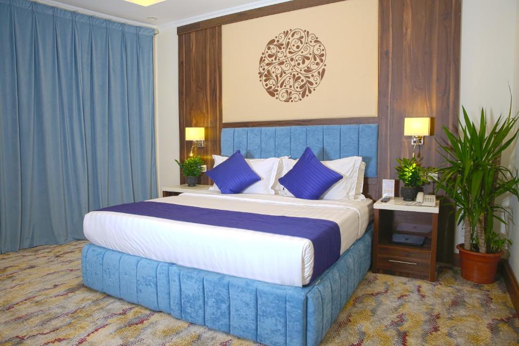吉赞فندق فاندال的一间卧室配有蓝色大床和蓝色枕头