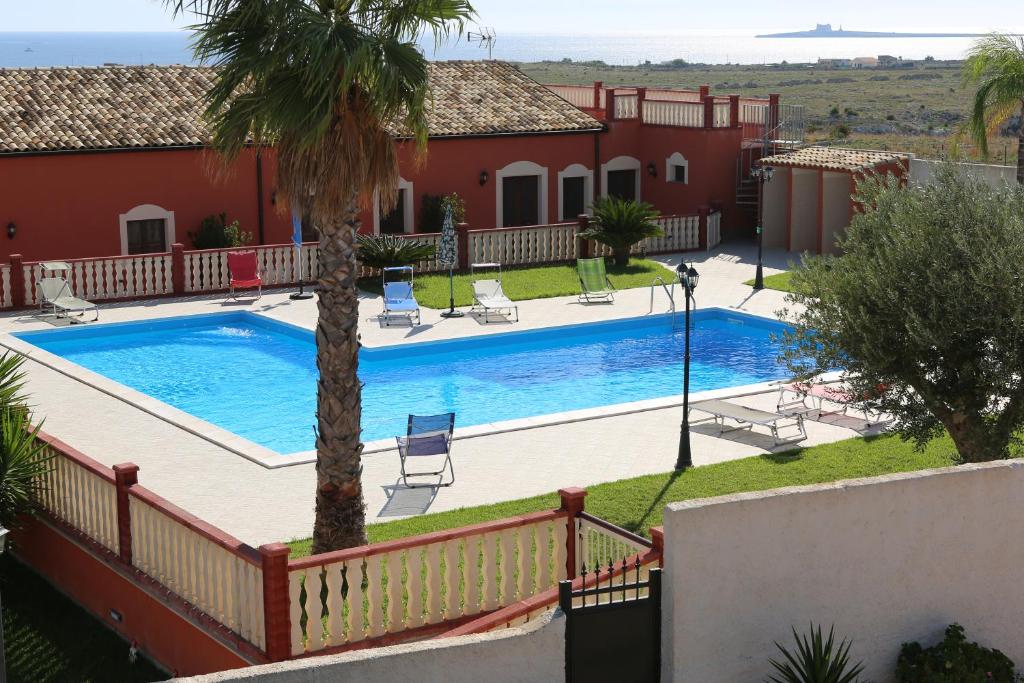 帕基诺Casa Vacanze Calafarina的房屋前的游泳池