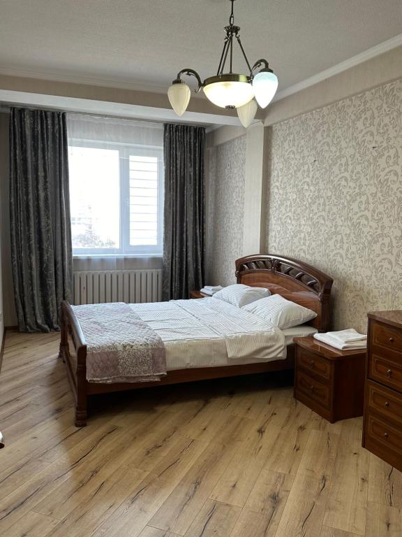 比什凯克guest house djal的一间卧室设有一张大床和一个窗户。