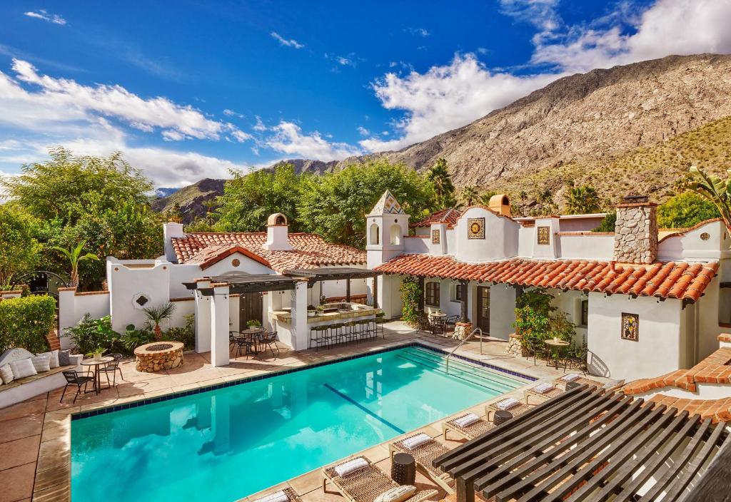 棕榈泉Lucille Palm Springs的一座带游泳池和山脉的房子