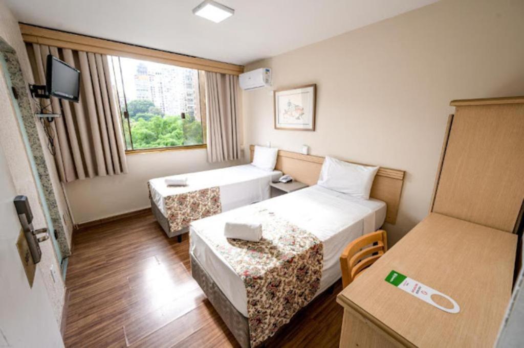 圣保罗Hotel Dan Inn São Paulo Higienópolis - METRÔ MACKENZIE的酒店客房设有两张床和窗户。