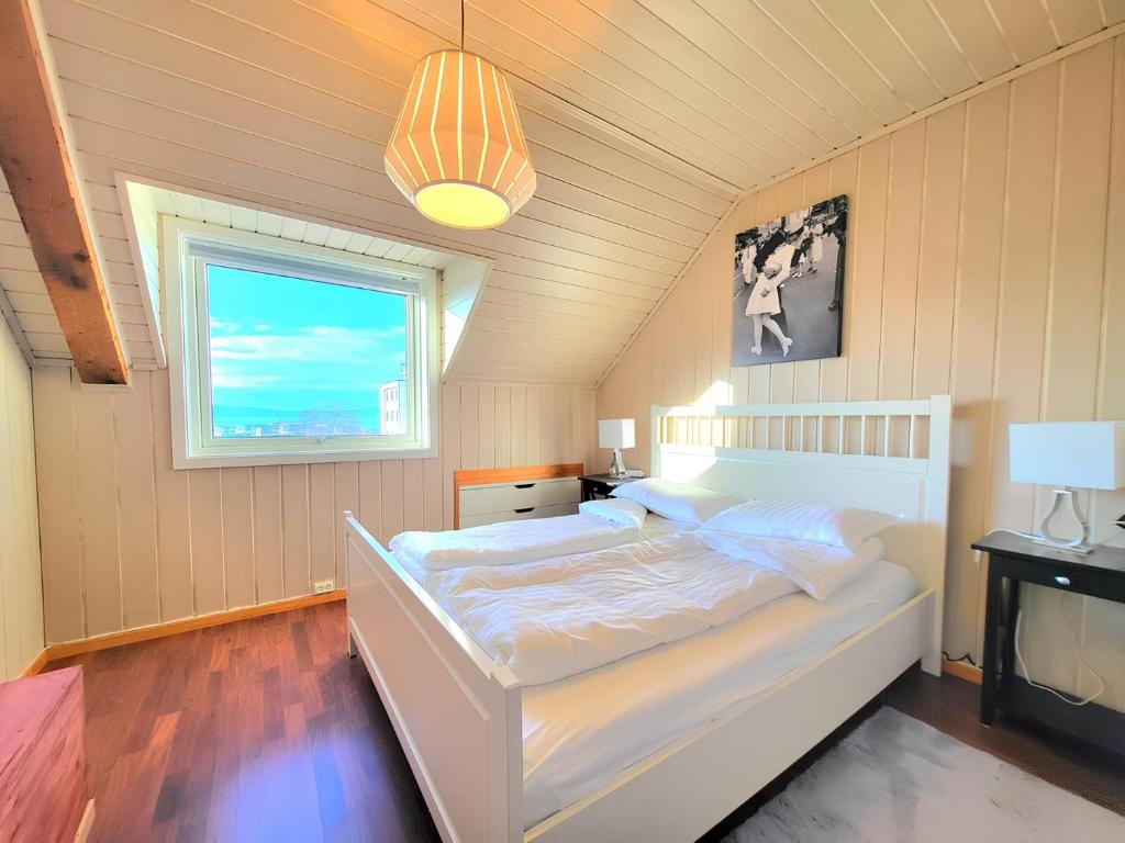 特隆赫姆Sunset Penthouse, Fjord View & Parking的卧室配有白色的床和窗户。