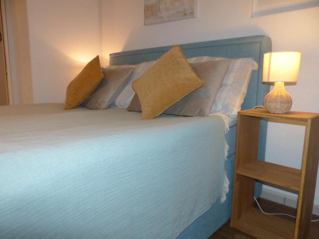 穆尔滕Sweet Home的一张带两个枕头的床和一张桌子上的台灯