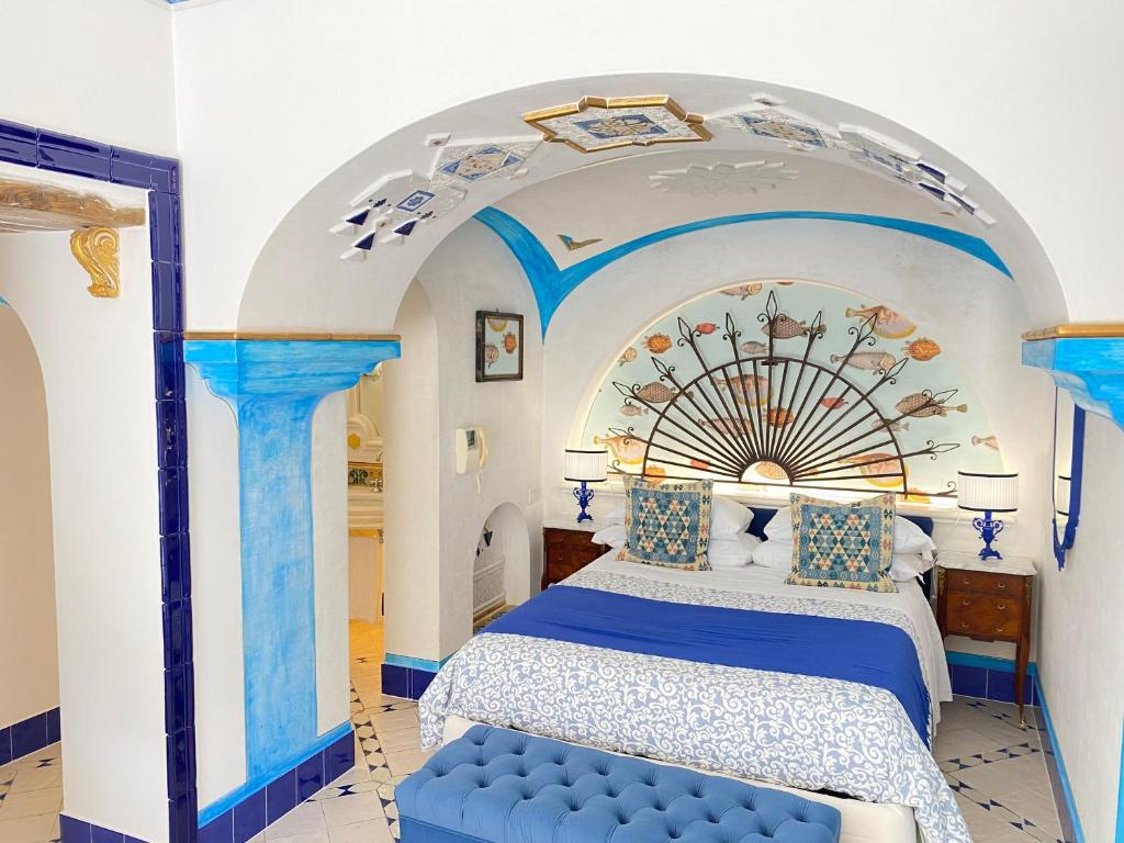 波西塔诺波西塔诺套房度假屋的一间卧室设有蓝色的床和拱门