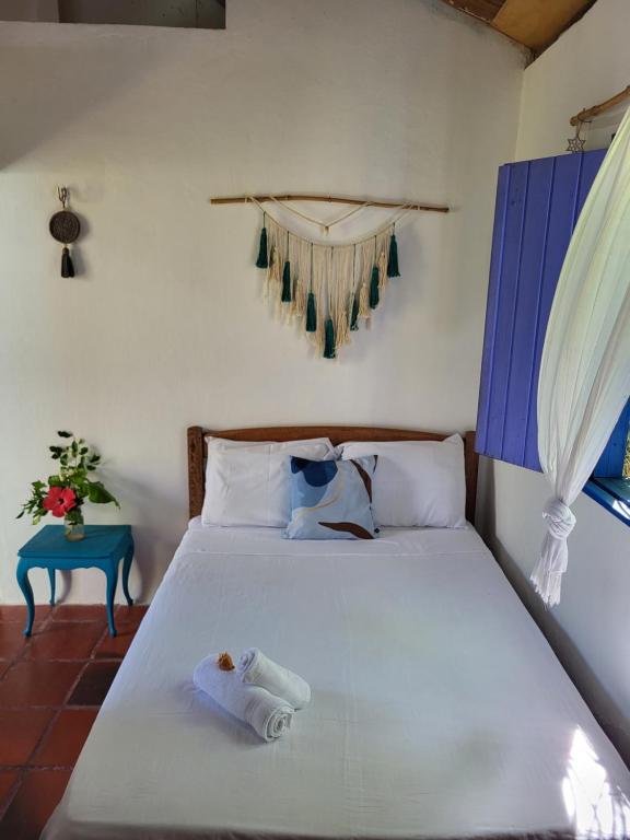 卡诺格布拉达Chalé Flor do ser的卧室配有一张白色的床和一张蓝色的桌子