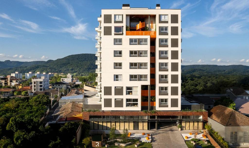 圣玛丽亚Morcelli Mobiliados - Uniqo Smart Living的一座高大的白色建筑,上面设有一个阳台