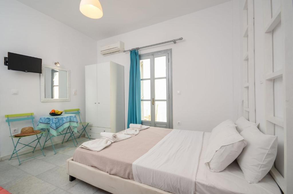 纳克索乔拉Luxury Naxos Apartment | Deluxe Triple Studio | 150m From St. George Beach | City Center | Saint George的白色卧室配有一张大床和一张桌子